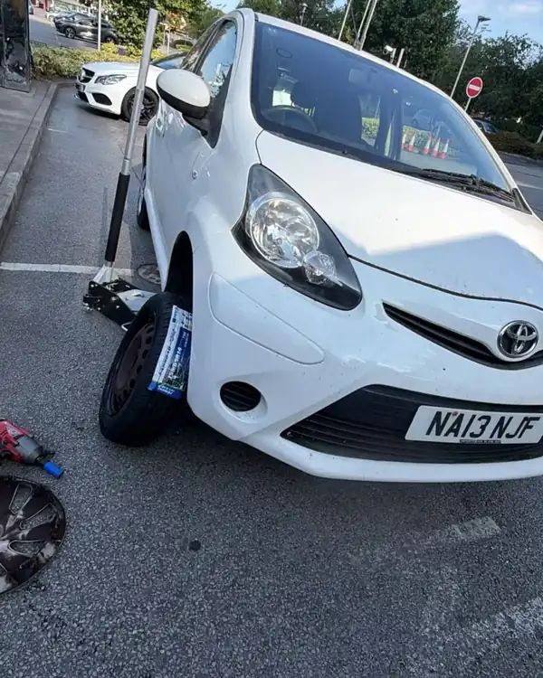 Toyota Aygo with a new tyre fitted in a car park